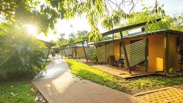 A pathway leading to outdoor seating areas with a view of a building and surrounding greenery.