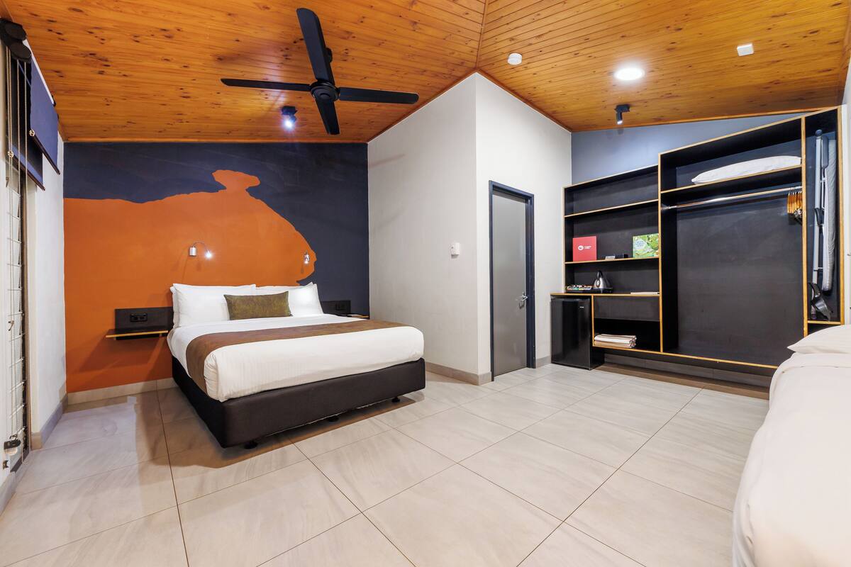 Une chambre moderne avec un lit, un plafond en bois et une armoire intégrée.