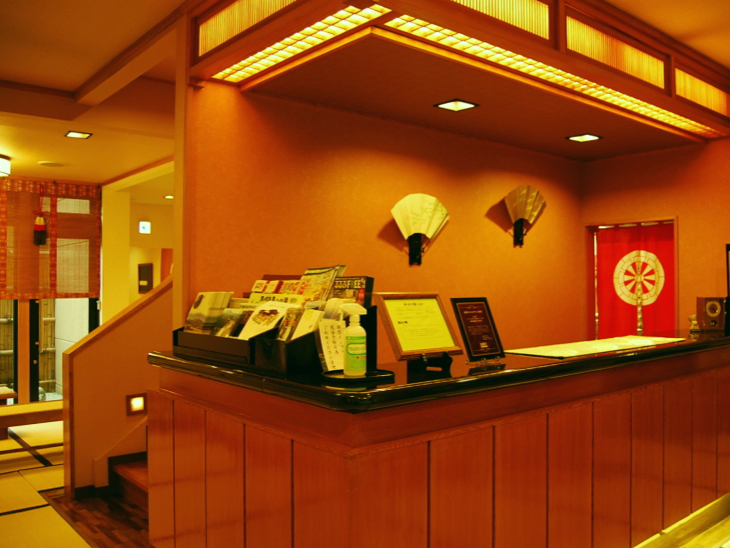 A reception desk with a red door, a fan, and a signboard.