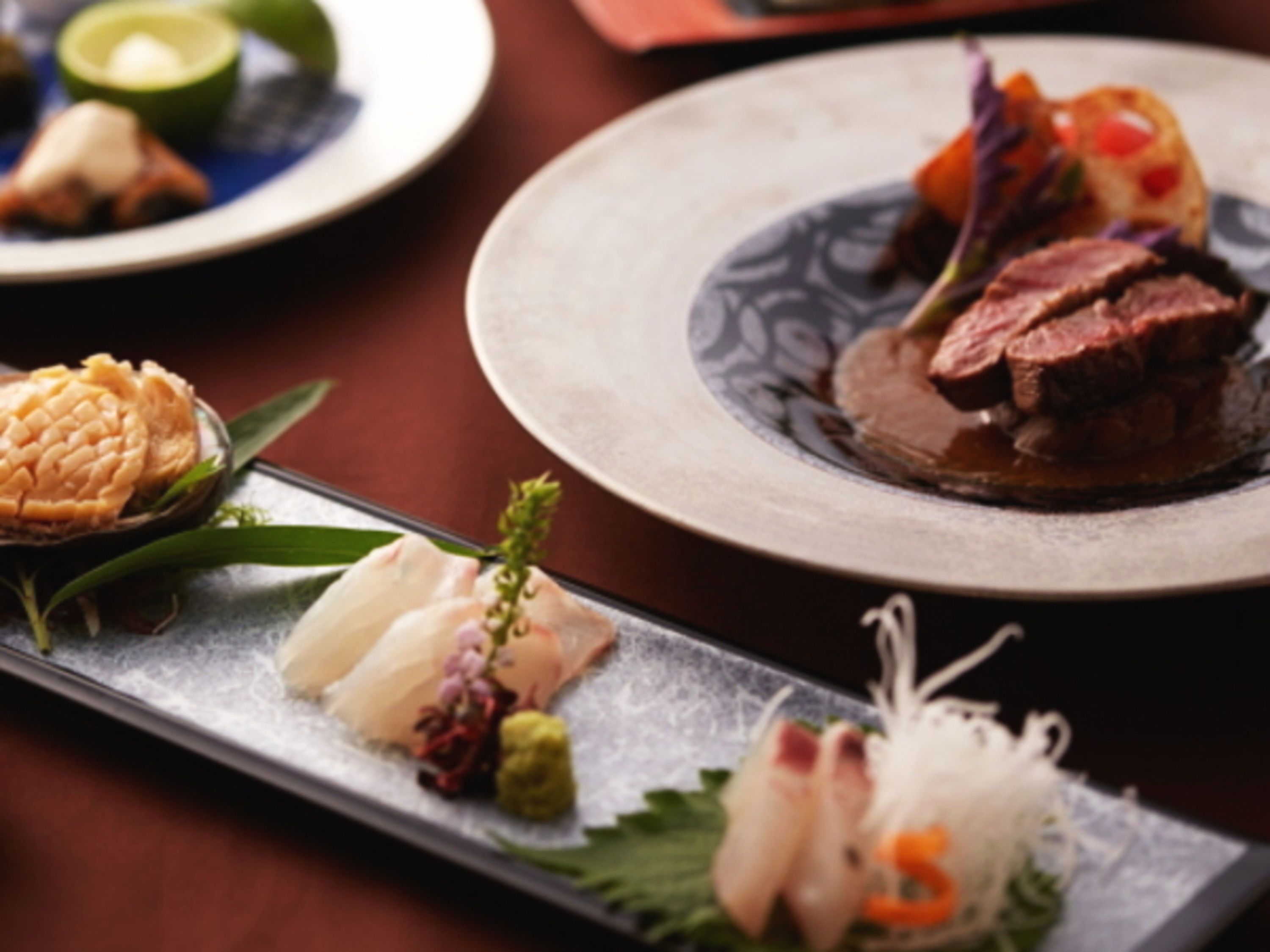 A dining table with various dishes, including a plate with sliced meat and vegetables, and another plate with a different dish.