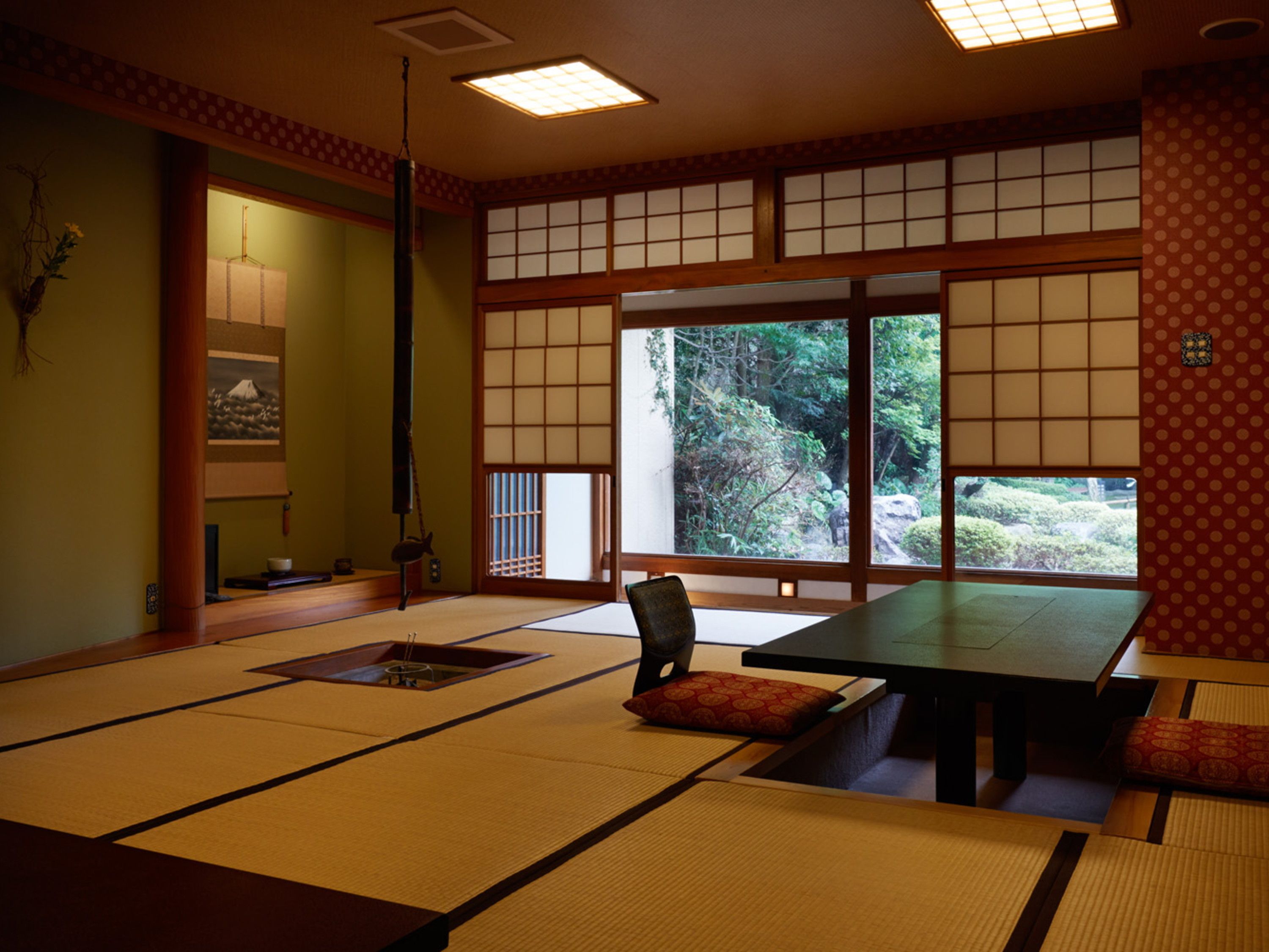 A traditional Japanese tatami room with tatami mats, a low table, and a sliding door leading to a garden.