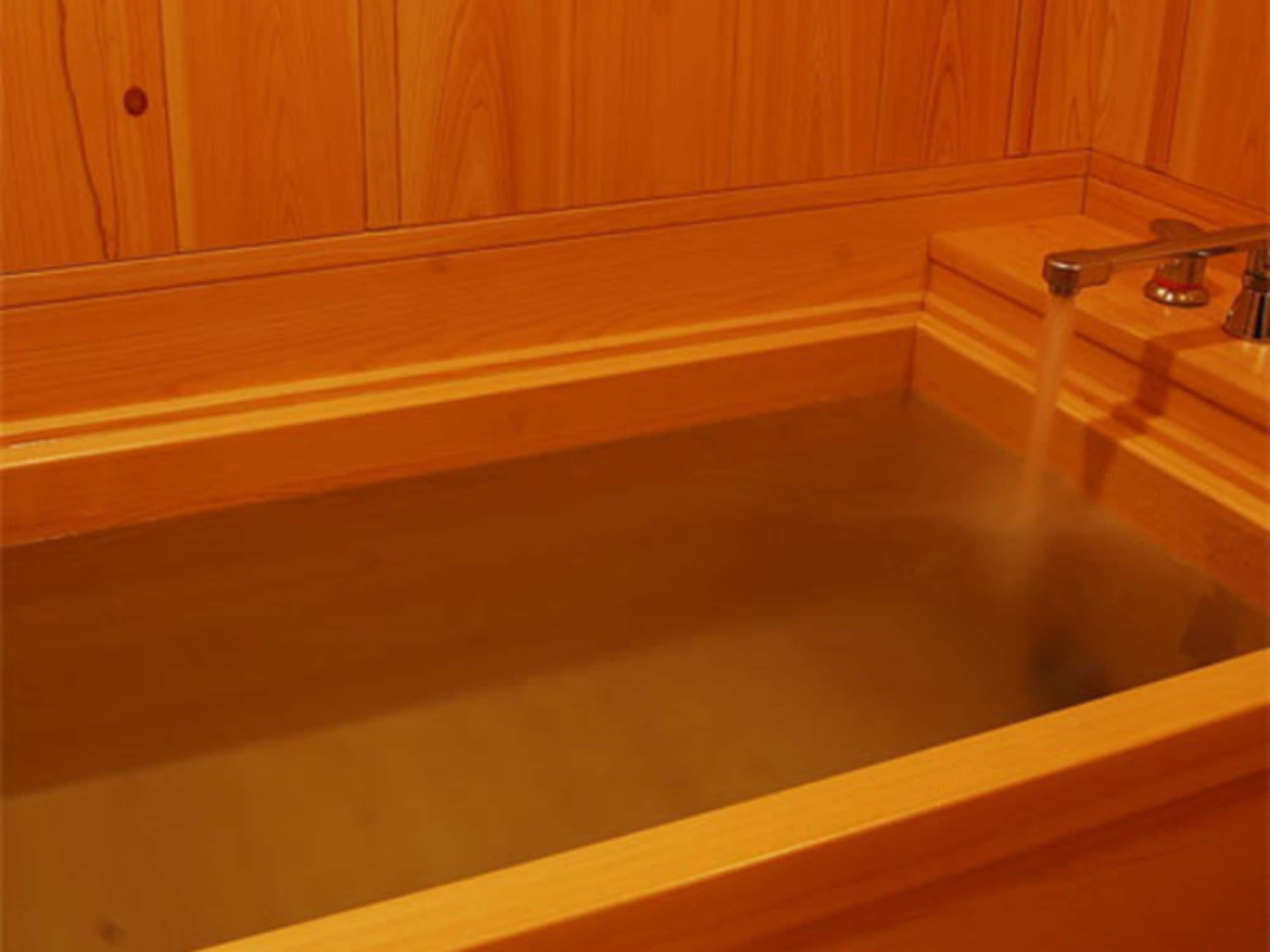 Una bañera de madera con agua corriente.