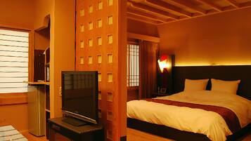 A hotel room with a bed, a TV, a desk, and a wardrobe.