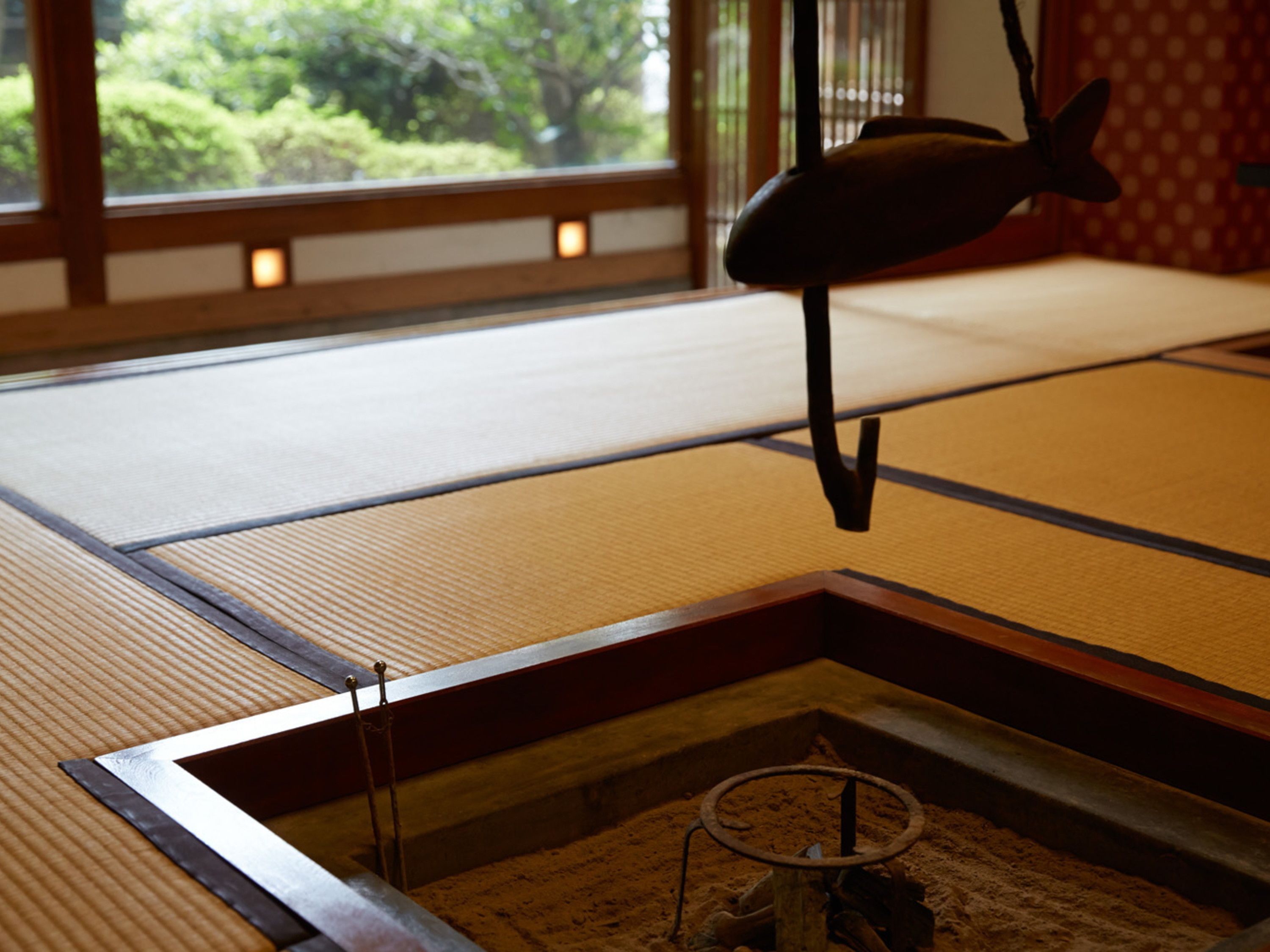 A tatami mat room with a low table and a hanging decoration.