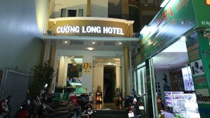 Un hotel de varios pisos con balcones y un letrero que dice "CUỐNG LONG HOTEL".
