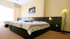 Una habitación de hotel con una cama grande, una mesita de noche, una lámpara y un cuadro en la pared.