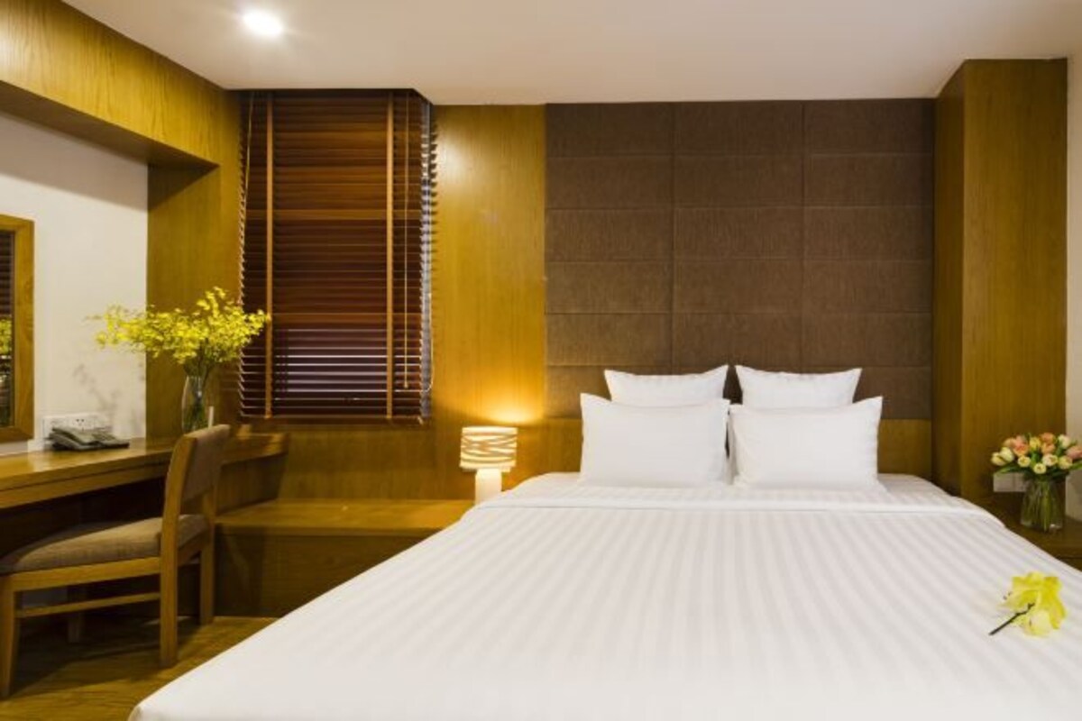 Una habitación de hotel con una cama, un escritorio y una silla.