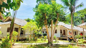 A tropical resort with thatched-roof cottages, lush greenery, and a clear sky. - Phuwadee Resort & Spa (Ko Pha-ngan)