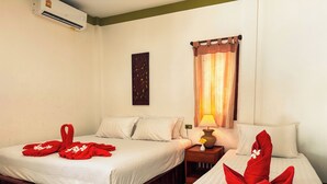 A hotel room with two beds, a nightstand, a lamp, and a wall-mounted air conditioner. - Phuwadee Resort & Spa (Ko Pha-ngan)