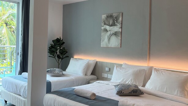A modern hotel room with two beds, a large window with a view of palm trees, and a ceiling fan. - White Lodge (Langkawi)