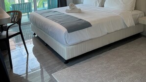 A modern hotel room with a large bed, a view of the outside balcony, and a painting on the wall. - White Lodge (Langkawi)
