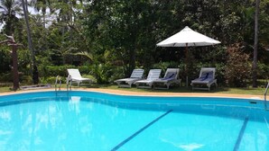 Ein Pool mit Liegestühlen und Sonnenschirm.