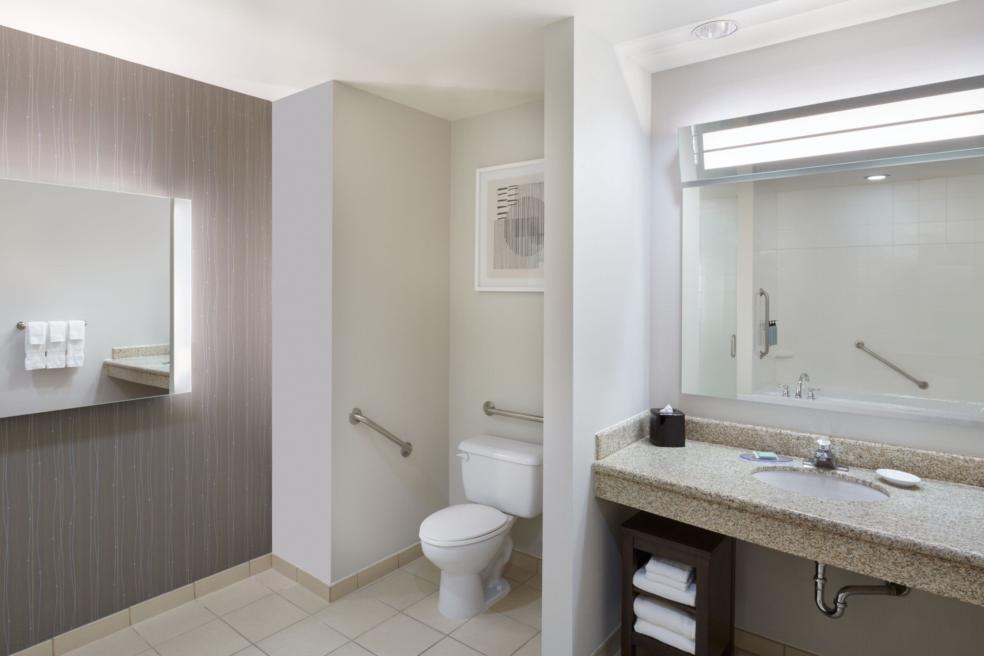 Un baño moderno con inodoro, lavamanos y espejo.