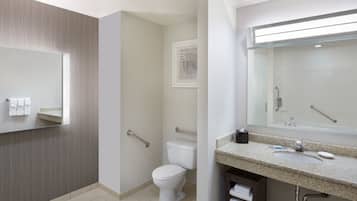 Un baño moderno con inodoro, lavamanos y espejo.