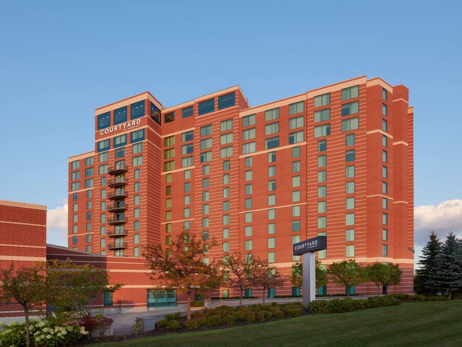 A multi-story hotel with a red brick facade, multiple balconies, and a sign indicating it is a Courtyard Inn.