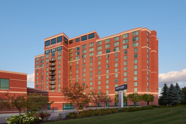 A multi-story hotel with a red brick facade, multiple balconies, and a sign indicating it is a Courtyard Inn. - Courtyard by Marriott Ottawa East (Ottawa)
