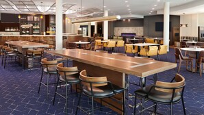 A modern restaurant with a long bar, multiple seating areas, and a bar area with a variety of seating options. - Courtyard by Marriott Ottawa East (Ottawa)