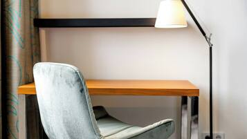Una silla con respaldo acolchado y un escritorio de madera con estructura metálica.