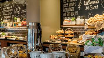 Un bufé de desayuno con diversas opciones de comida y bebidas.