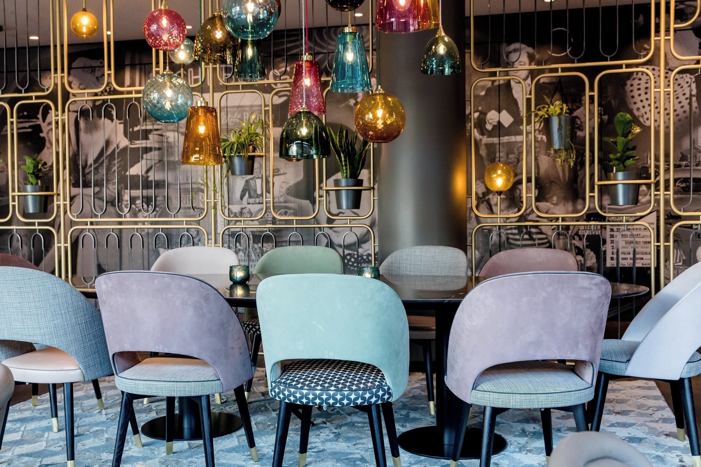 Een modern interieur met meerdere stoelen en hangende decoratieve verlichting.