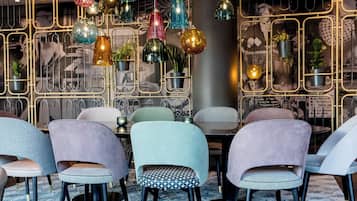 Een modern interieur met meerdere stoelen en hangende decoratieve verlichting.