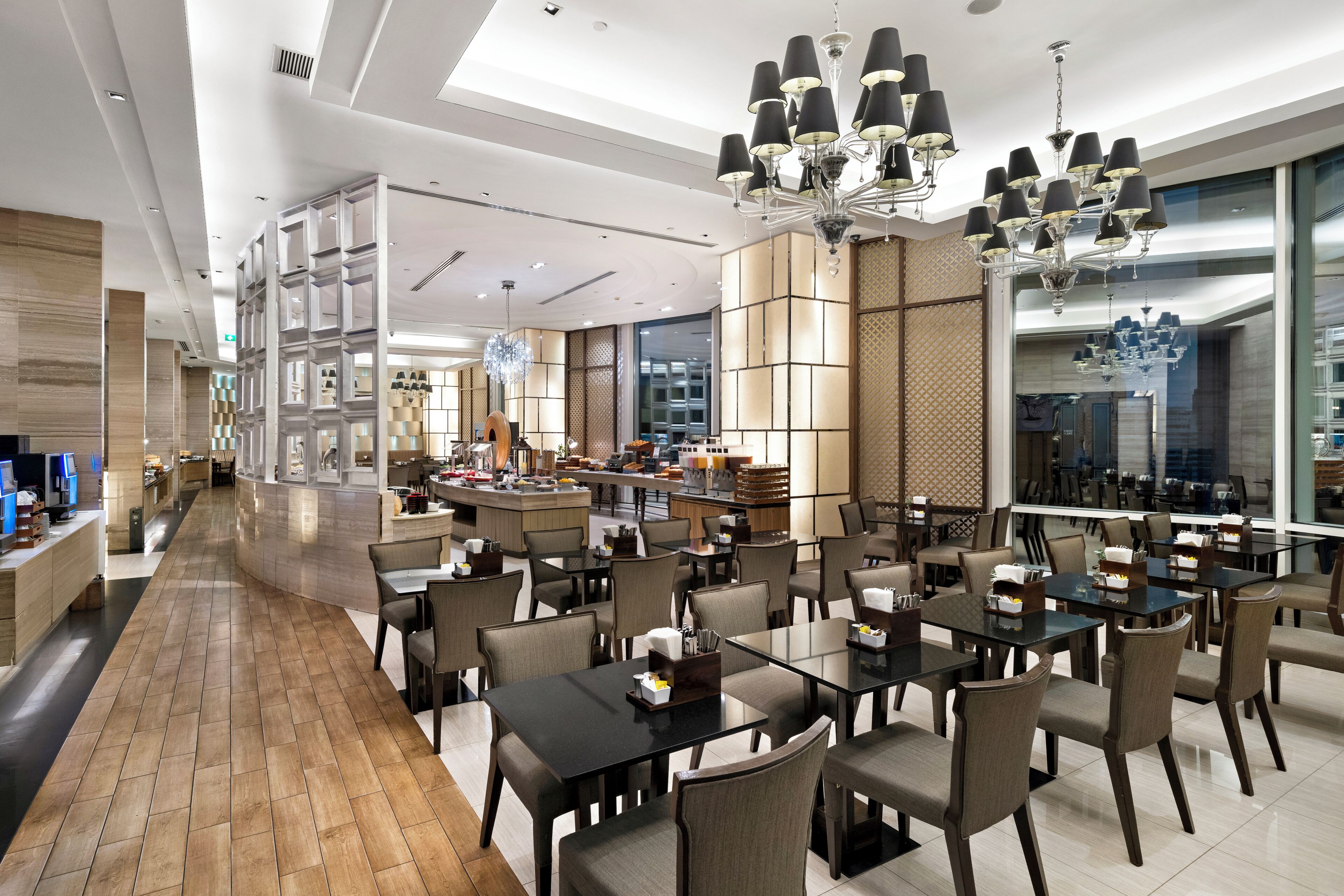 A modern restaurant with a long counter, multiple tables, and a central bar area.