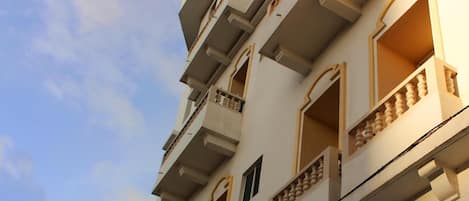 Un immeuble à plusieurs étages doté de balcons et de grandes fenêtres.