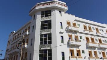 Un edificio de varios pisos con balcones y ventanas amplias.
