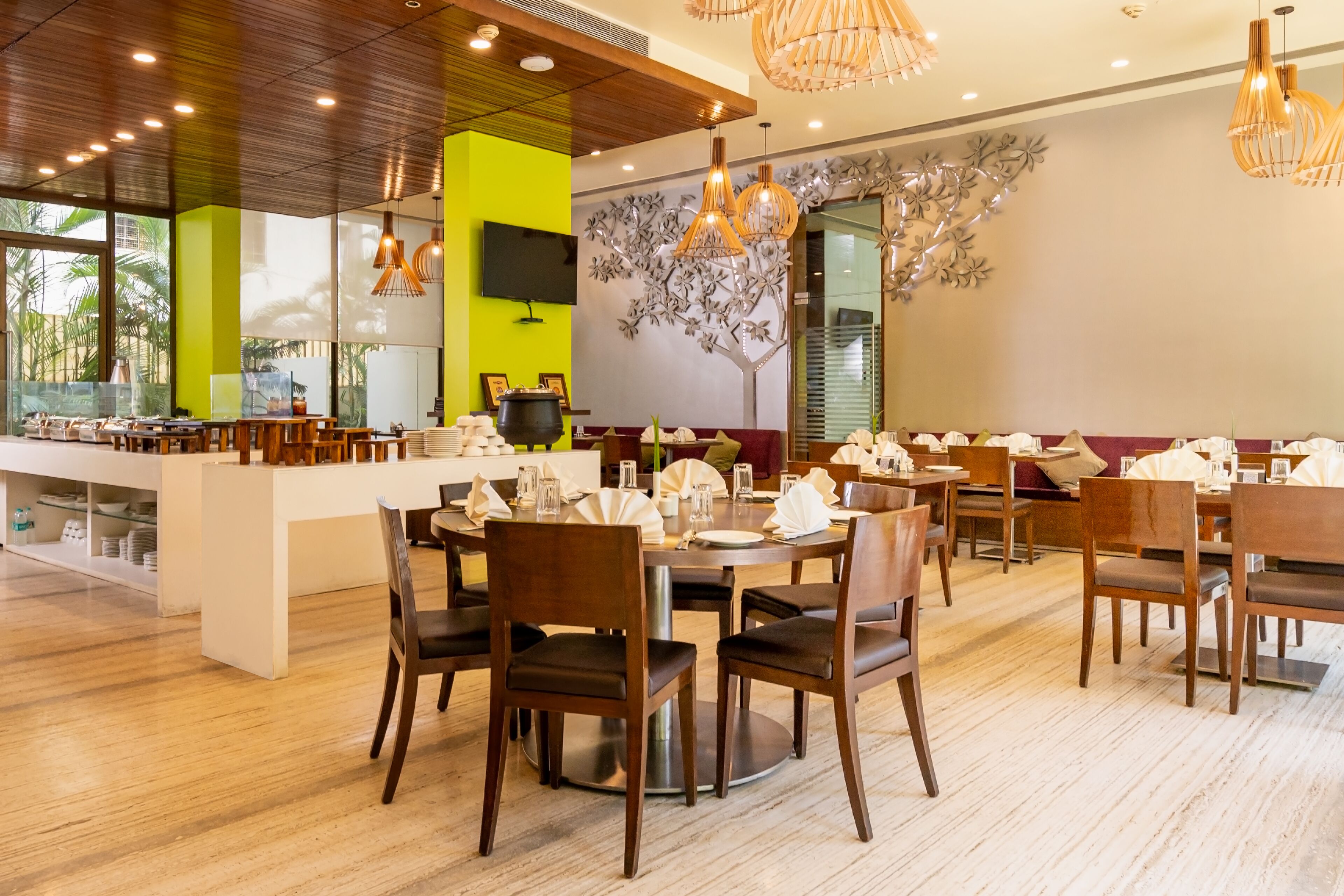 A modern restaurant with wooden furniture, a central island, and decorative wall art.