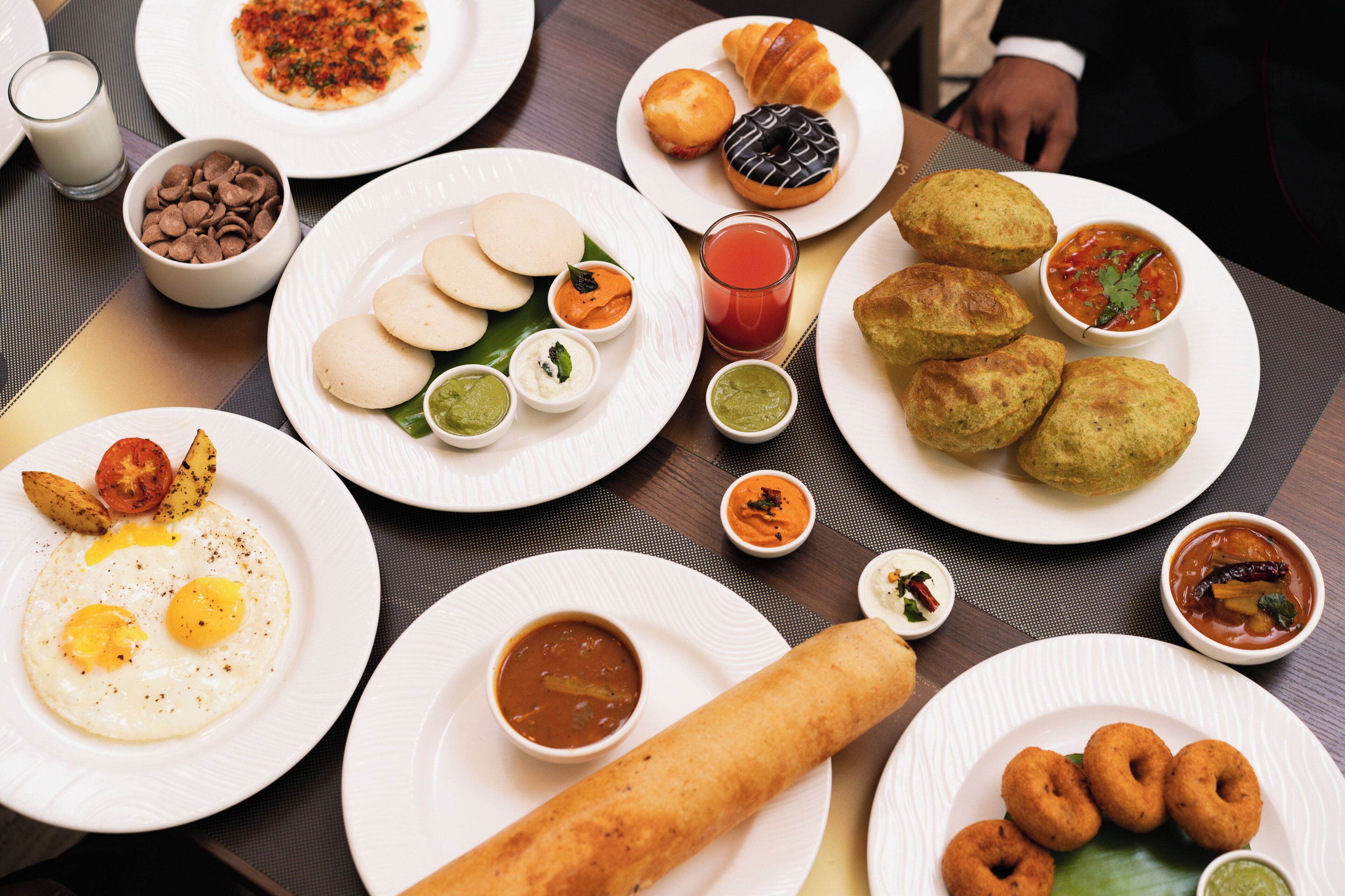 A table with various dishes including eggs, bread, and sauces.