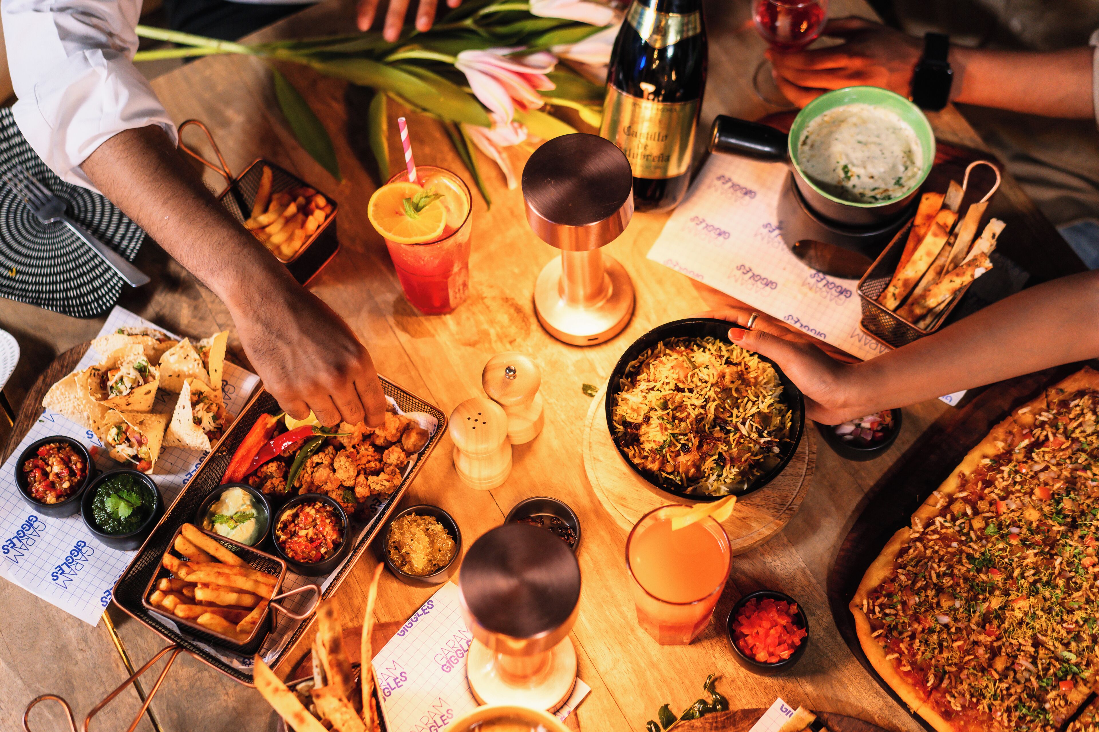 A table with various dishes, drinks, and a pizza.