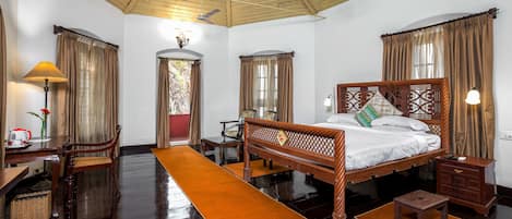 A traditional room with a wooden bed, a desk, and a chair.