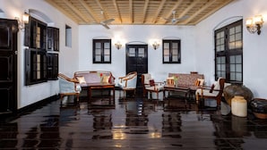 A spacious room with wooden furniture, a large vase, and a ceiling fan. - Koder House Heritage Hotel & Spa (Kochi)