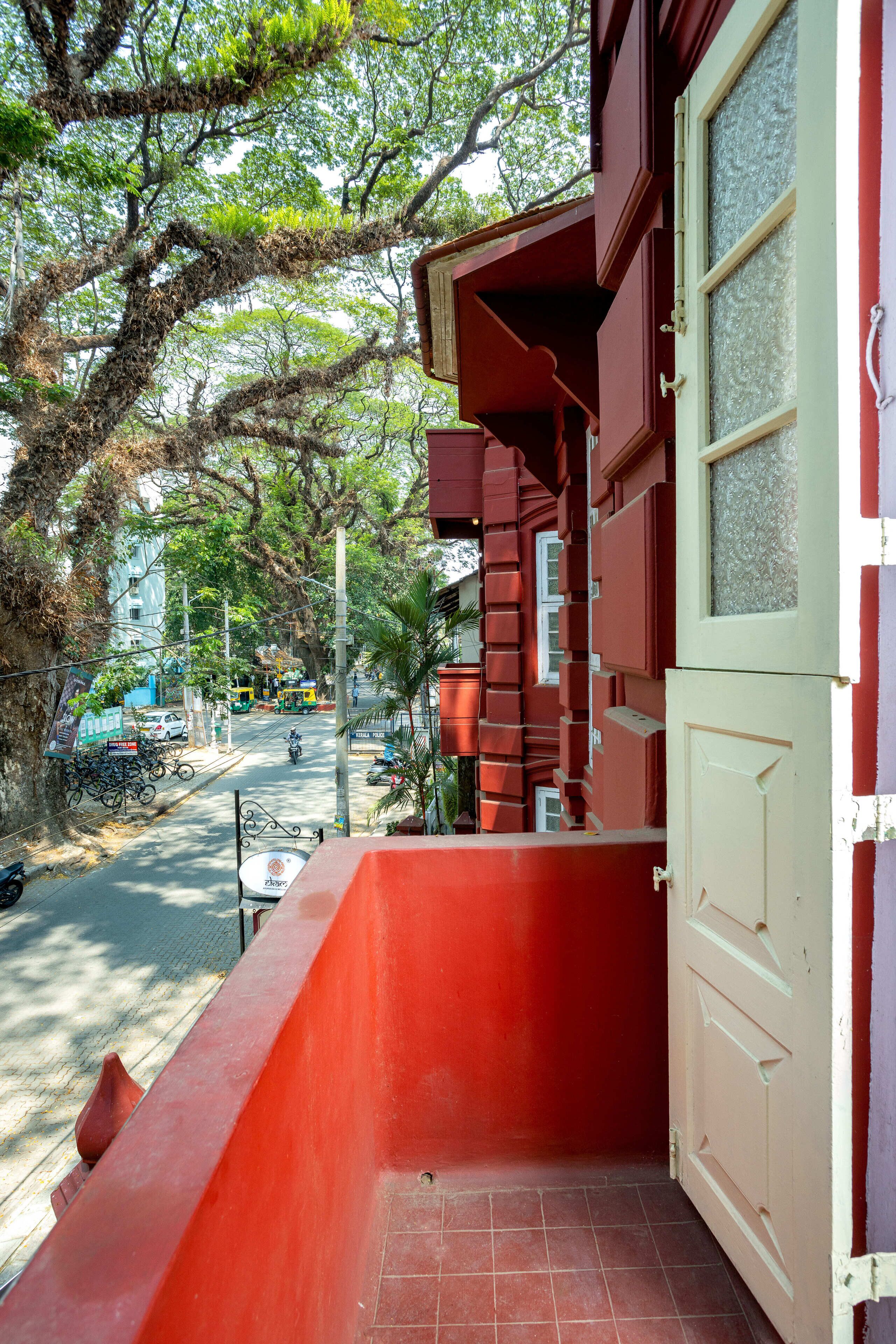 Un bâtiment rouge doté d’un balcon donnant sur une rue.