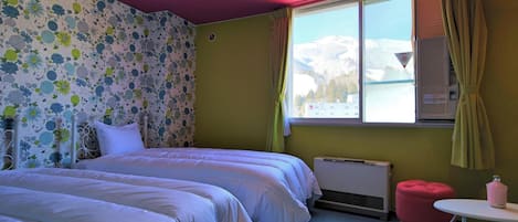 Quarto com duas camas, janela com vista para montanhas nevadas, radiador e uma pequena mesa com abajur rosa.