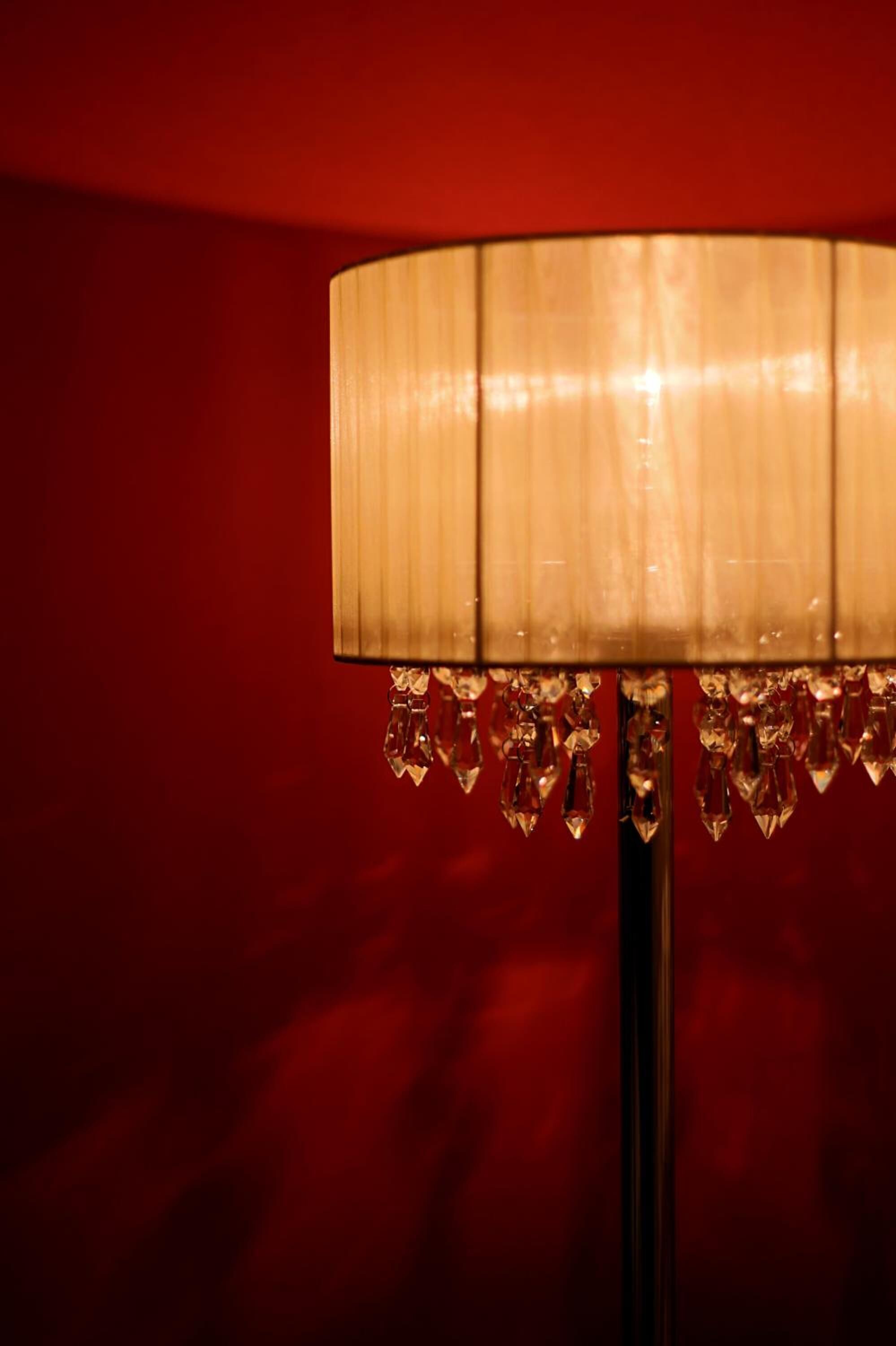 Uma luminária com cúpula cilíndrica e detalhes em cristais.
