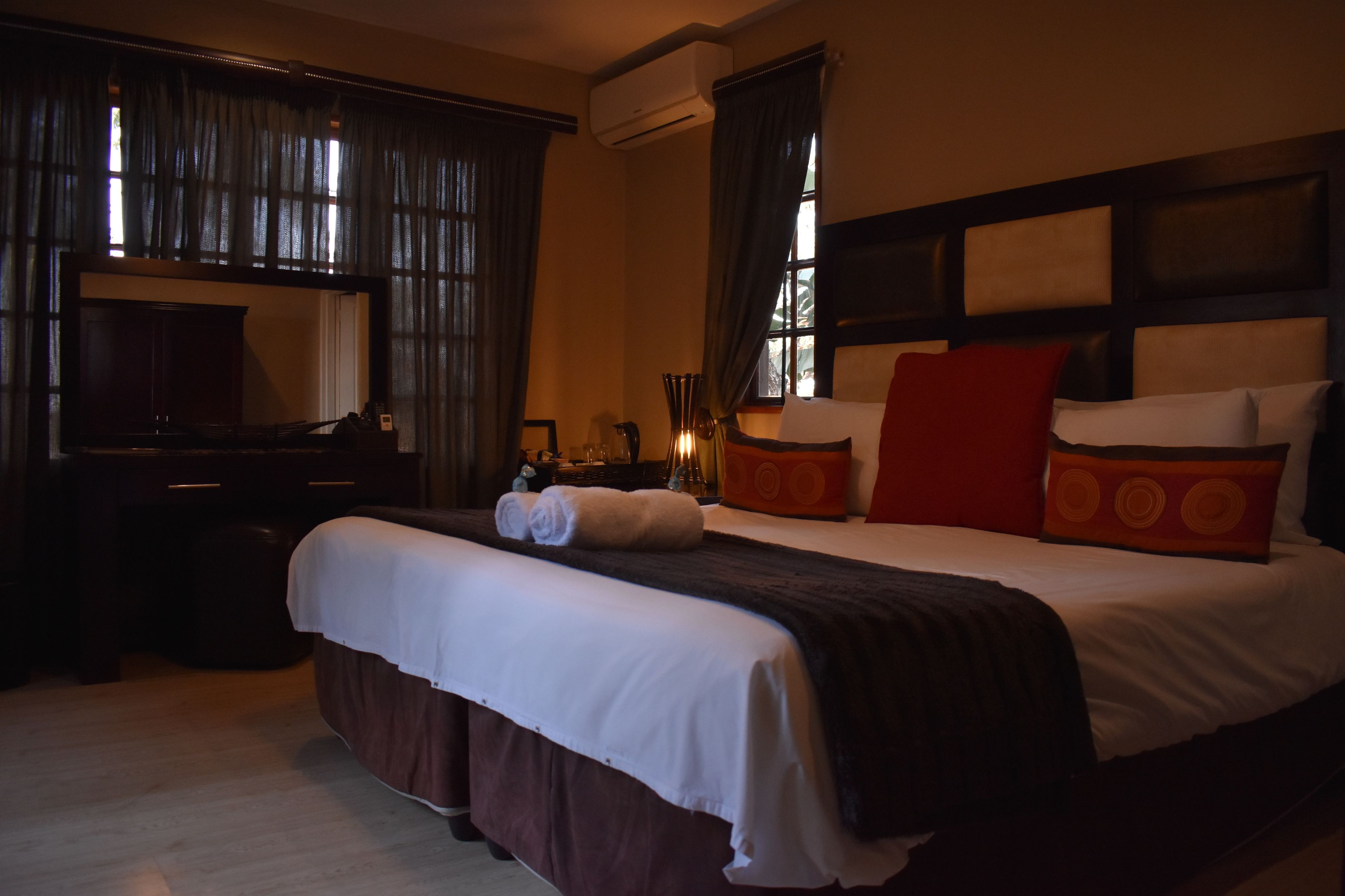 A hotel room with a large bed, a desk, and a television.