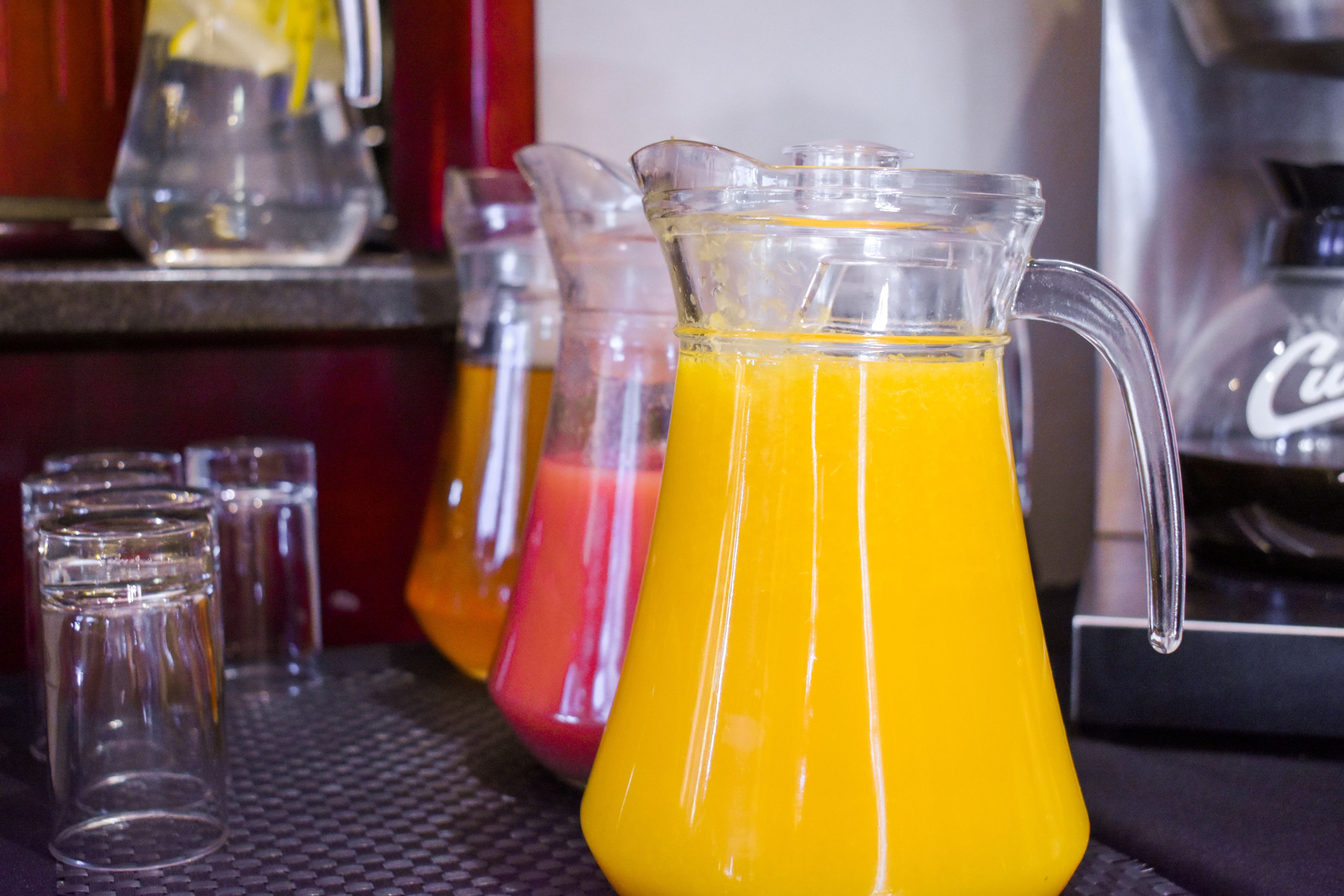 Angolo bar con una caraffa di succo d'arancia e diversi bicchieri.