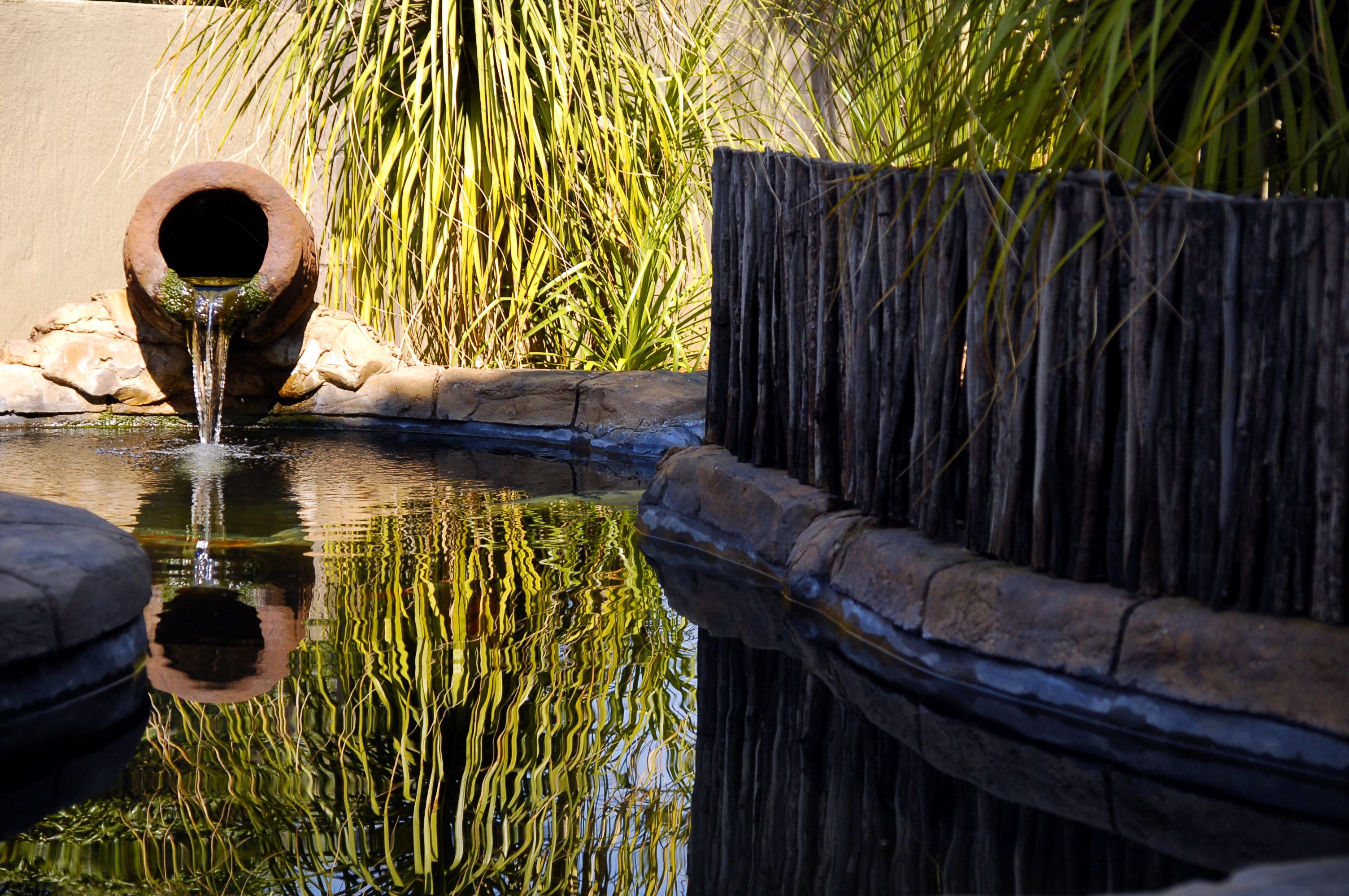 Un élément décoratif aquatique composé d’une tuyauterie et d’une clôture en bois.