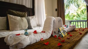 A neatly made bed with white towels, a book, and a glass of water. - Waterfalls Boutique Hotel (Pretoria)