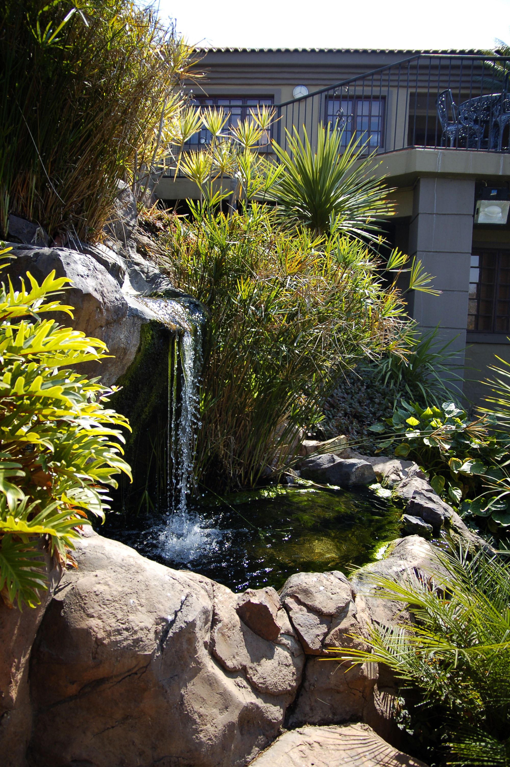 A waterfall cascading over rocks with lush greenery around it.