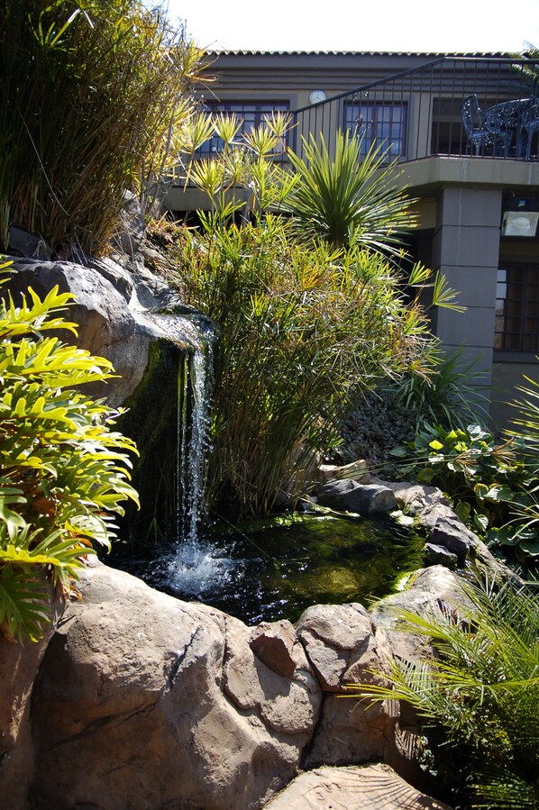 A waterfall cascading over rocks with lush greenery around it.