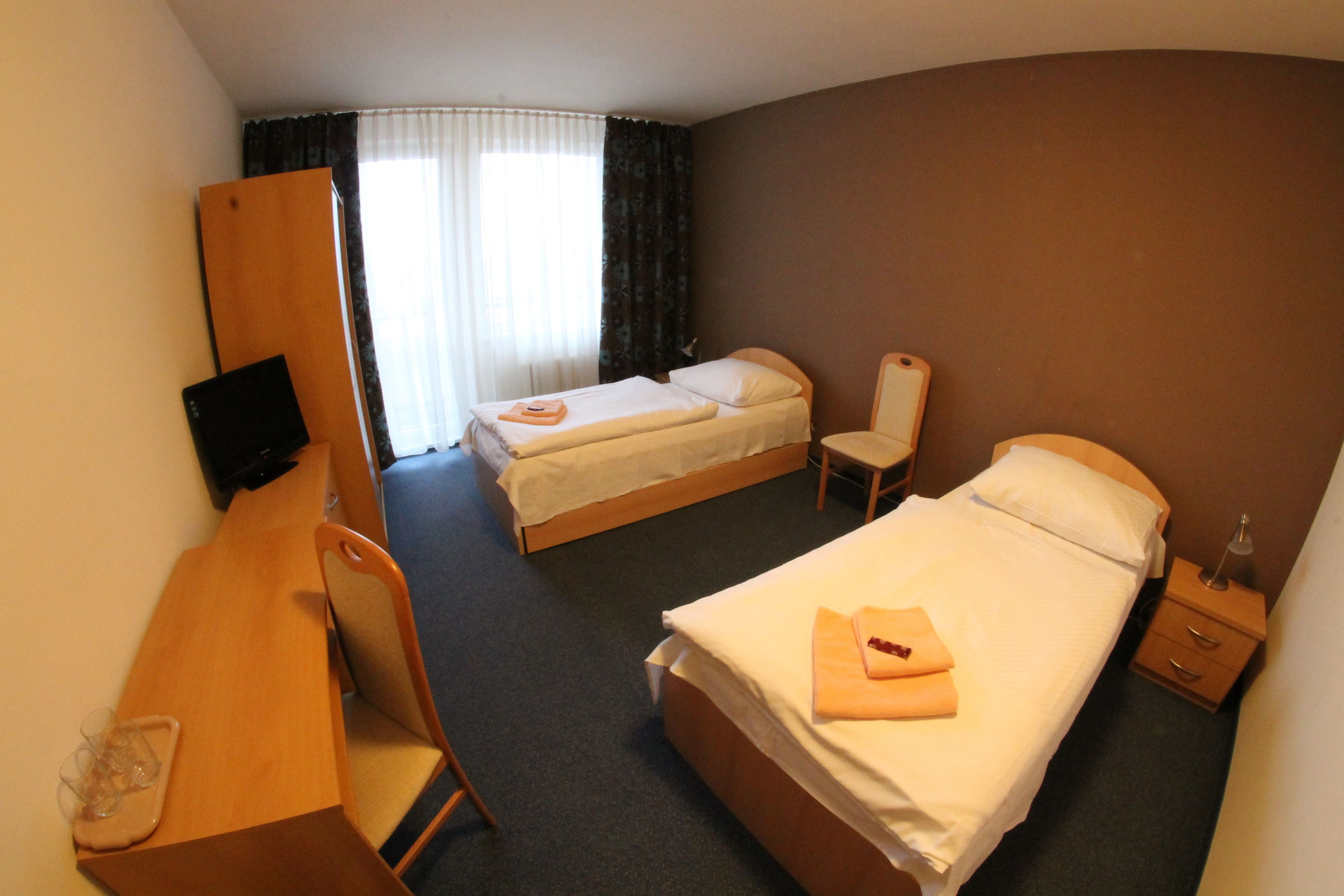 Una habitación de hotel con una cama, un escritorio, una silla y un televisor.