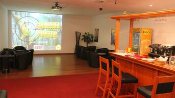 A bar area with wooden chairs and a red carpet.