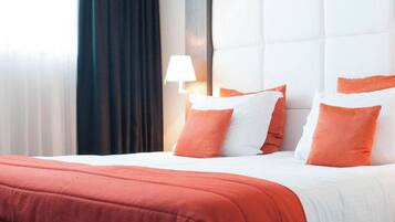 A hotel room with a bed, a headboard, and a nightstand with a lamp.