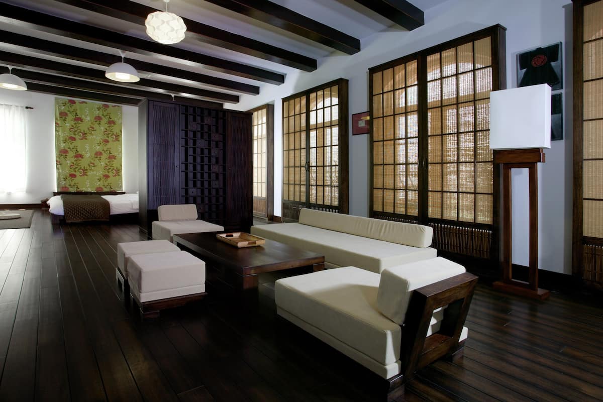 Une pièce de style japonais traditionnel, avec un sol recouvert de tatamis, une basse table en bois, un canapé et des portes coulissantes en papier de riz (shoji).