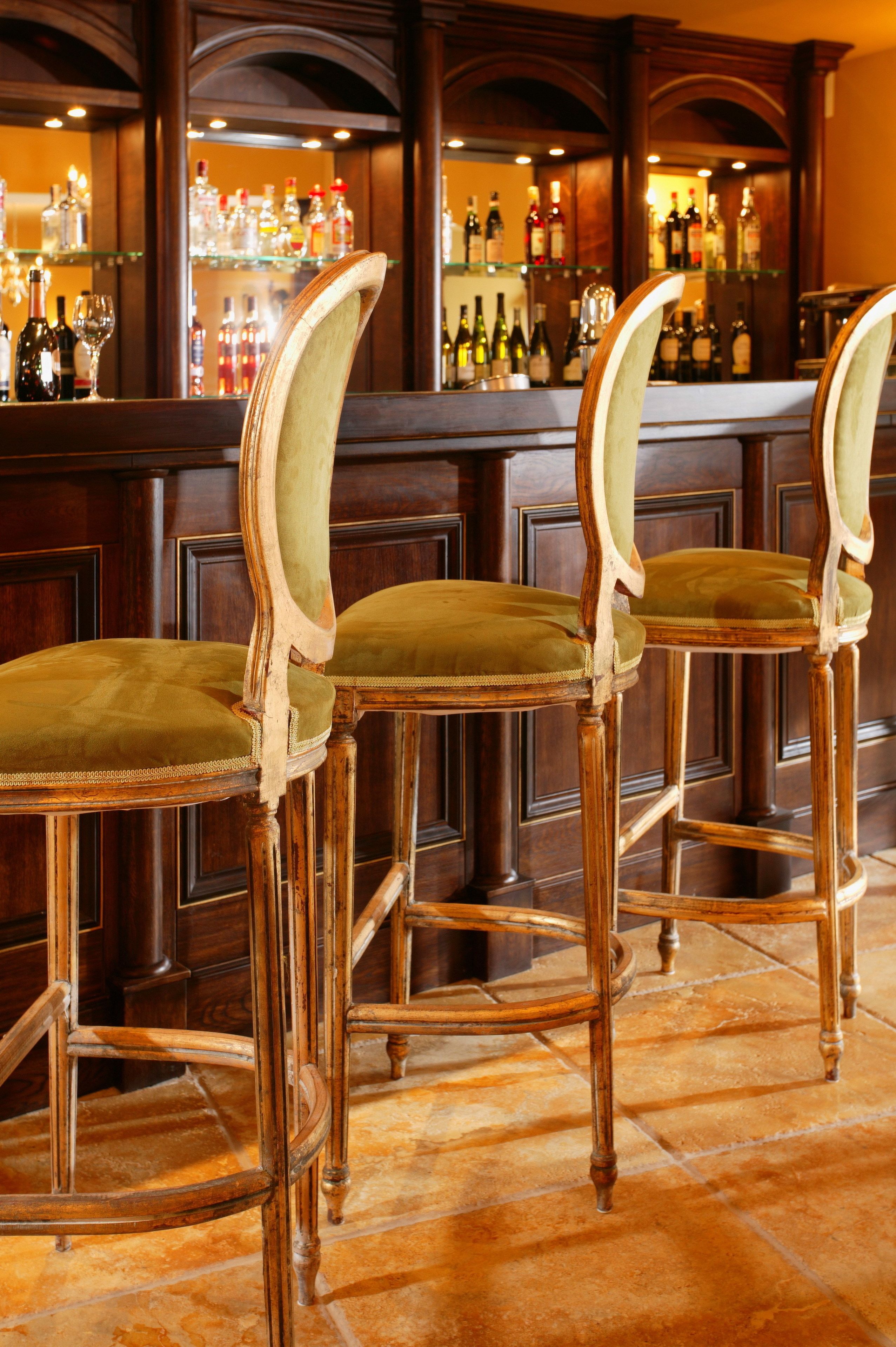 Un espace bar avec des chaises en bois et un comptoir.