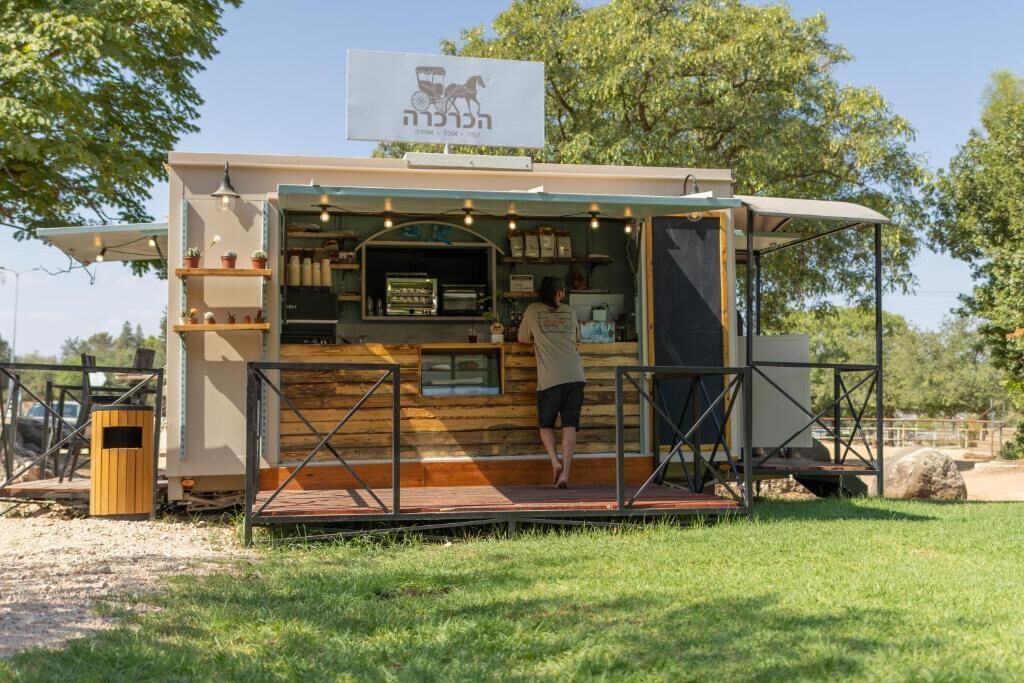 A food truck with a sign, a counter, and a person standing by the counter.
