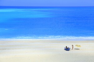 Una playa cerca, arena blanca, sillas reclinables de playa, sombrillas