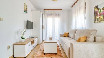 Lägenhet Deluxe - 1 sovrum - balkong - havsutsikt | Vardagsrum | 32-tums LCD-tv med satellitkanaler och tv